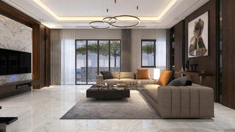 Cách trang trí phòng khách cao cấp được thiết kế để tạo ra một cảm giác ấn tượng bằng cách đối lập giữa hai mảng tường chính: bức tranh canvas trừu tượng nâu trầm tương phản với sự mạnh mẽ của khối đá đối vân lớn.